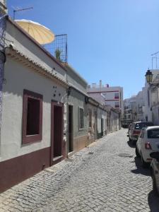 an empty street with a building and an umbrella at Casa das Andorinhas in Faro