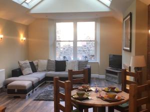 a living room with a couch and a table at HomeArms Cottage in Eyemouth