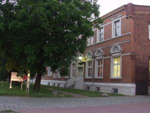 ein großes Backsteingebäude mit einem Schild davor in der Unterkunft Pension Zum Engel in Magdeburg