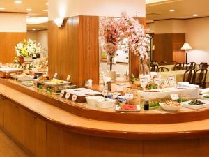 a buffet line with plates of food and flowers at APA Hotel Sapporo Susukino Eki Nishi in Sapporo