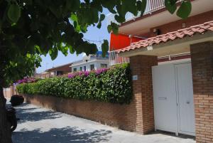 a brick building with a white door and flowers at Apartamento Maraka Playa Castelldefels in Castelldefels