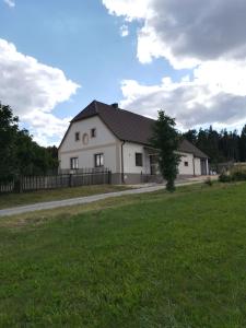 a white house with a fence and a grass field at Chalupa u lesa - Nova Ves in Český Rudolec
