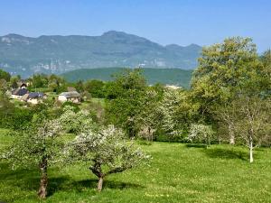 um campo com árvores e casas e montanhas ao fundo em Le pré aux clercs em Trévignin