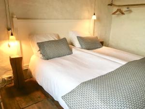 a bedroom with two beds with white sheets and blue pillows at Le pré aux clercs in Trévignin