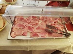 Fogliano MarinaにあるLocanda della lunaの一組のトングを乗せた肉のトレイ