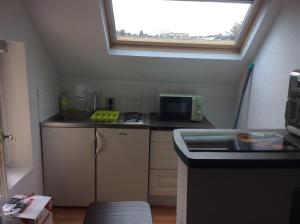 eine kleine Küche mit einem Waschbecken und einem Fenster in der Unterkunft L'appart de Clea in Montluçon