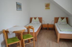 a room with two beds and a table and chairs at Frühstückspension Sterr in Strebersdorf