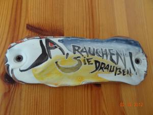 un objet en forme de poisson avec un visage sur celui-ci; dans l'établissement Küstenferienhaus Nr. 91/92, à Stahlbrode