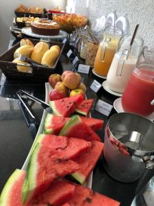 a table with a plate of watermelon and other fruits at New Concept Hotel in Goiânia