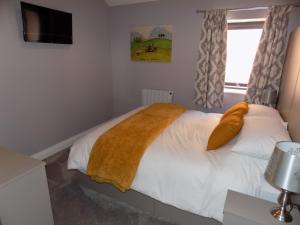 a bedroom with a white bedspread and pillows at The Old Wool House Apartments in Carlisle