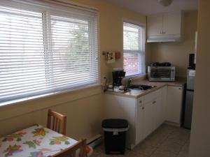 a small kitchen with a sink and a microwave at Johnny's Motel in Grand Forks