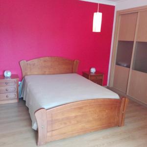 ポルティマンにあるMar Atlantico Apartmentのピンクの壁のベッドルーム1室(木製ベッド1台付)