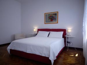 a bedroom with a large white bed with a red headboard at Polly House in Treviso