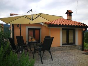 a patio with a table and a large umbrella at House Čeh in Črni Kal