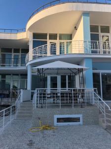 a building with a patio with an umbrella in front of it at Apartamenty u moria in Karolino-Buhaz