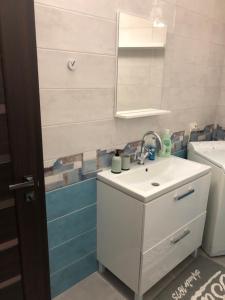 La salle de bains est pourvue d'un lavabo blanc et d'un miroir. dans l'établissement Apartamenty u moria, à Karolino-Buhaz