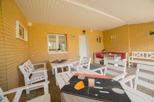 a room with white chairs and a table and a table and a table at Noclegi u Zygmunta in Mielno