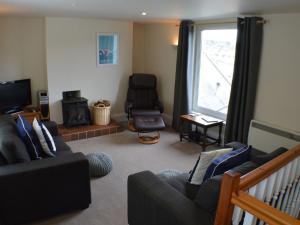 a living room with a couch and a chair and a window at Chapel House - Stunning River Views, Sunny Balcony with Parking in Dartmouth