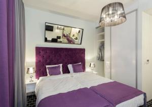 une chambre violette avec un grand lit avec une tête de lit violette dans l'établissement Apartamenty Vola Residence, à Varsovie