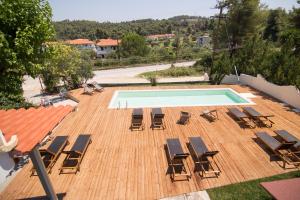 una terraza con tumbonas y vistas panorámicas a la piscina en Casa Luxury Suites en Paliouri