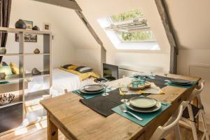 a dining room with a table and a bedroom at Le 45 in Isigny-sur-Mer