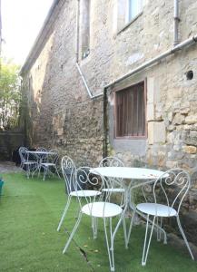 a group of tables and chairs in front of a building at Le 45 in Isigny-sur-Mer