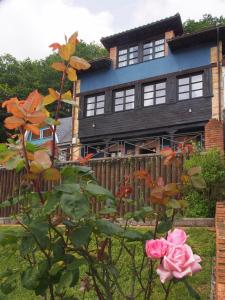 una casa con una valla y una rosa rosa en Casas Rurales Asturias Campon Antrialgo, en Infiesto