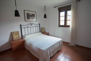 - une chambre avec un lit blanc et une fenêtre dans l'établissement Los Candiles, à Cangas de Onís