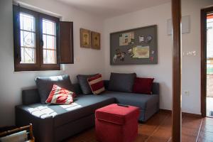 sala de estar con sofá y taburete rojo en Los Candiles, en Cangas de Onís