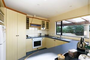 a kitchen with white cabinets and a large window at Rifugio - Lake Tekapo in Lake Tekapo