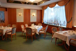 a dining room with tables and chairs and a window at Hotel Meyn in Soltau