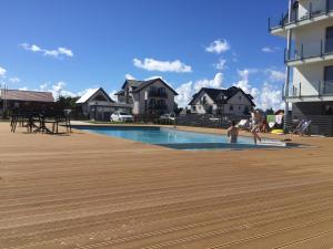 a couple of people are playing in a swimming pool at Baltic Apartament z basenem zewnętrznym ul Marynarska 4, Sarbinowo in Sarbinowo