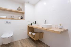 a bathroom with two sinks and a toilet at GETARIA APARTAMENTUAK - Sahatsaga in Getaria