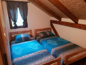two twin beds in a room with a window at Kuća za odmor "Gećat" in Kulen Vakuf