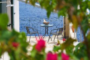 a patio with a table and chairs and the water at Villa Apoplous with pool in Asos
