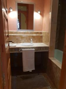 La salle de bains est pourvue d'un lavabo, d'un miroir et d'une baignoire. dans l'établissement Palmeraie village, à Marrakech