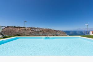 una gran piscina azul con vistas al océano en Beyond Amadores by Vector, en Mogán