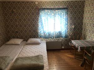 a bedroom with two twin beds and a window at Annexet Gästgivaregården Sunne in Sunne