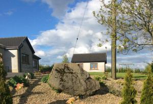 a house with a large rock in front of a house at Erne View Cottage in Kesh