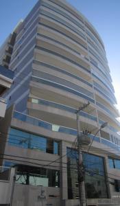 un edificio alto con una luz de la calle delante de él en Apartamento a 200 m da Praia do Morro, en Guarapari