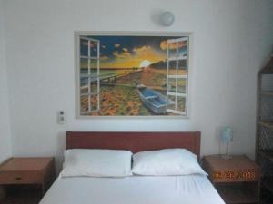 um quarto com uma cama com um quadro na parede em La Mansion del Rodadero em Santa Marta