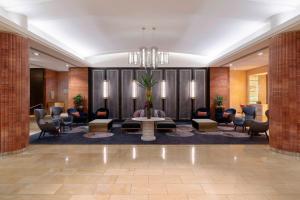 a lobby with a waiting area with a table and chairs at Amora Hotel Jamison Sydney in Sydney
