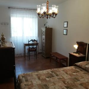 una camera con letto, tavolo e lampadario a braccio di Casa Fermina a 5 minuti da Sulmona a Introdacqua