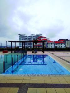 une grande piscine en face d'un bâtiment dans l'établissement Shah Suites Vista Alam, à Shah Alam