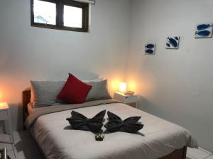 ein Schlafzimmer mit einem Bett mit zwei schwarzen Blumen drauf in der Unterkunft Kathy’s Place in Karimunjawa