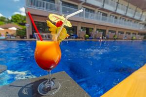 a drink sitting on a table next to a swimming pool at Srisuksant Resort in Ao Nang Beach
