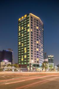 a tall building at night with a street in front of it at Sotetsu Hotels The Splaisir Seoul Dongdaemun in Seoul