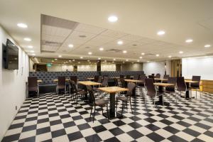 um restaurante com mesas e cadeiras num piso de xadrez em Good Life Hotel - Shang Hwa em Taipei