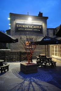 un bâtiment avec un panneau sur son côté dans l'établissement Sturdys Castle, à Kidlington