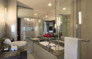 a bathroom with a sink and a tub and a mirror at Anantara Riverside Bangkok Resort - SHA Plus Certified in Bangkok